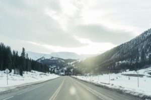 Open road through mountains with snow on the ground -Open Road in the Mountains - Denver's February Market Trends